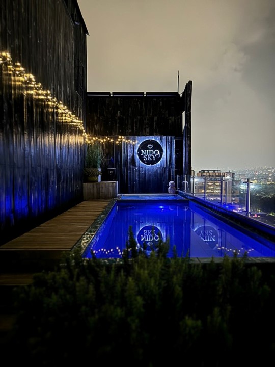 Outdoor rooftop pool and jacuzzi with city views at Nido Sky Hotel Medellin